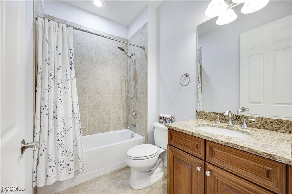 11758 Izarra Way, Unit 7703 Fort Myers, FL 33912 - Photo 13 of 37 a bathroom with a granite countertop sink a toilet and shower