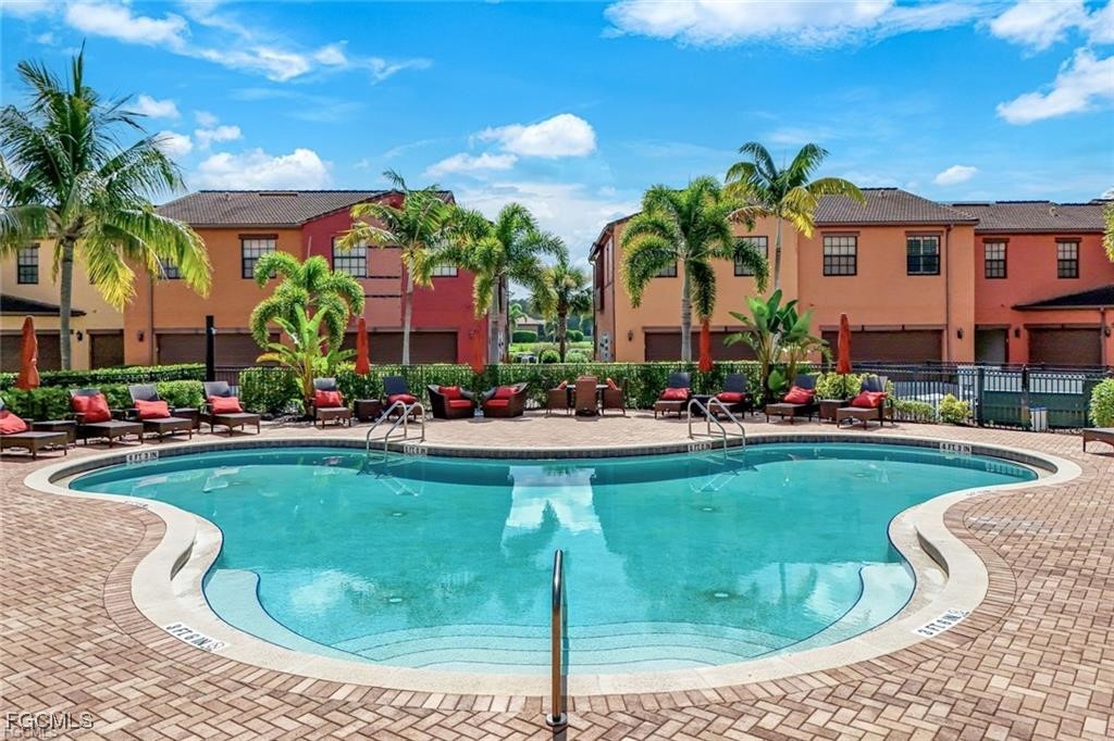 11758 Izarra Way, Unit 7703 Fort Myers, FL 33912 - Photo 21 of 37 a swimming pool with outdoor seating and yard