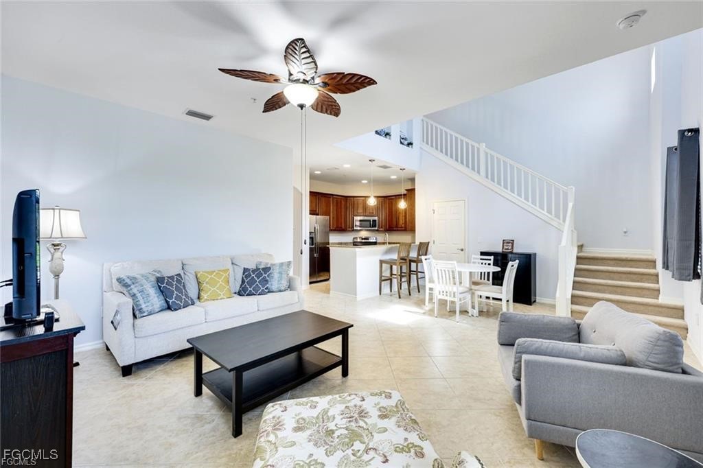 11758 Izarra Way, Unit 7703 Fort Myers, FL 33912 - Photo 5 of 37 a living room with furniture kitchen view and a chandelier