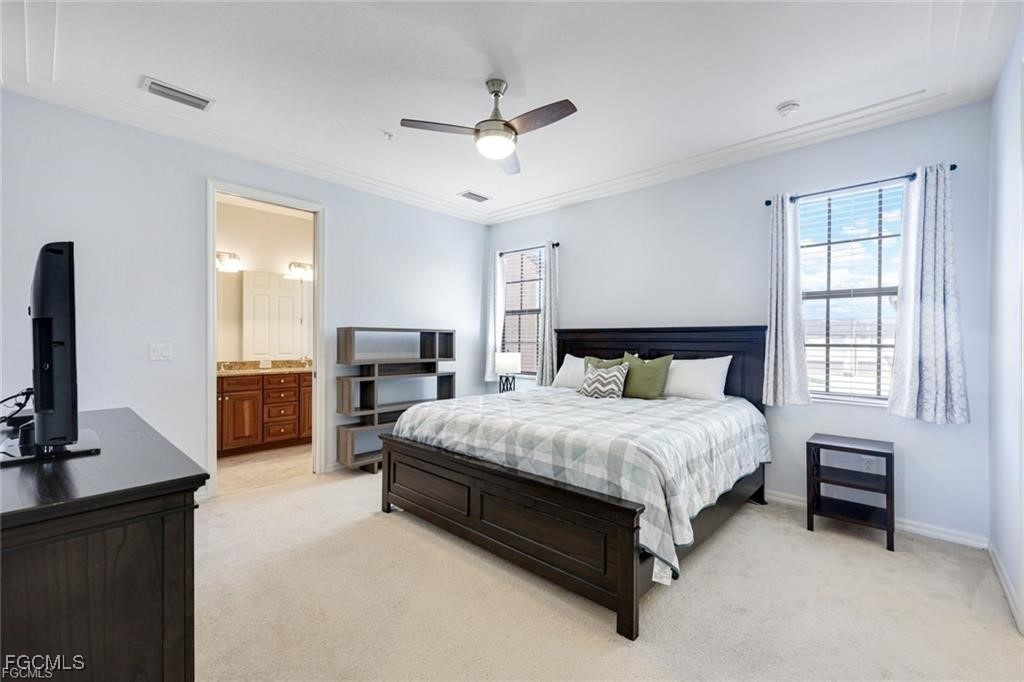 11758 Izarra Way, Unit 7703 Fort Myers, FL 33912 - Photo 10 of 37 a spacious bedroom with a bed and a flat tv screen on dresser