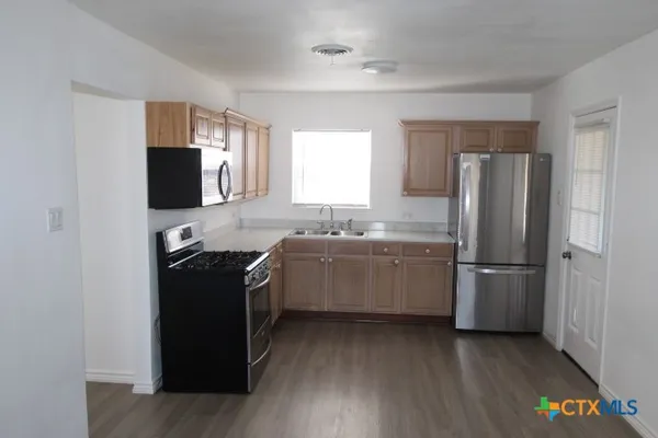 a kitchen with a refrigerator stove and sink