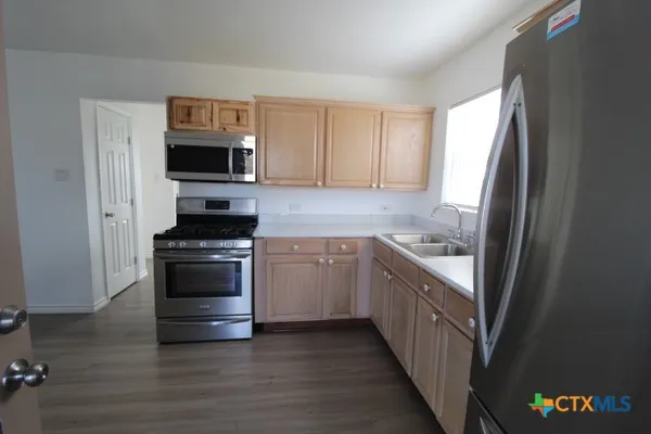 a kitchen with stainless steel appliances a stove microwave and refrigerator