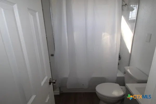 a white toilet sitting next to a shower