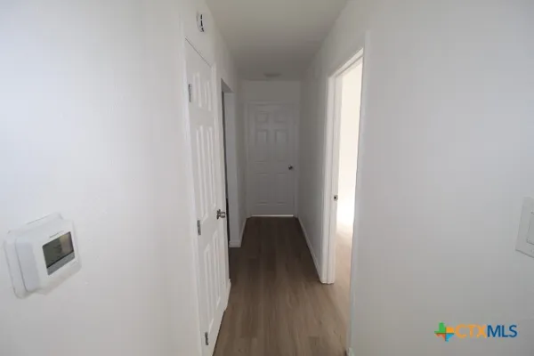 a view of hallway with stairs and wooden floor