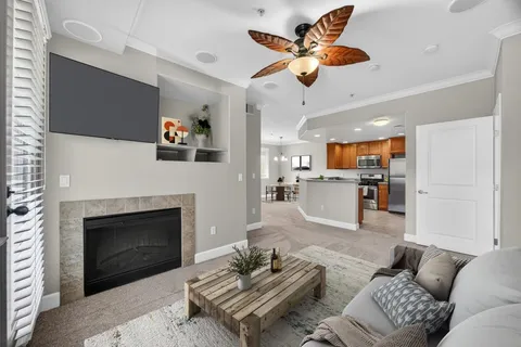 a living room with furniture kitchen view and a fireplace