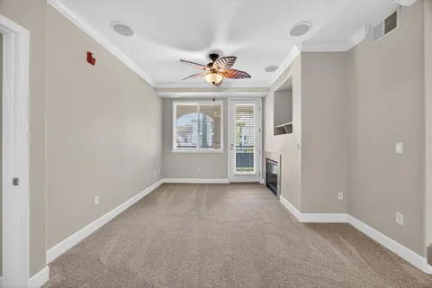 an empty room with windows and ceiling fan