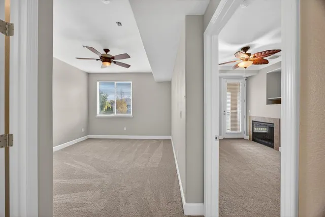 a view of an empty room with a fireplace and a window