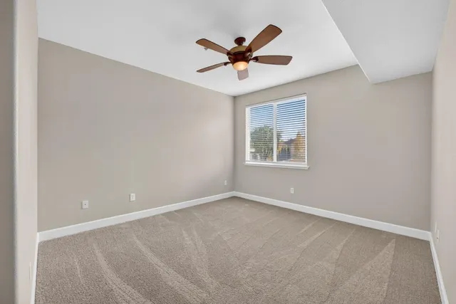 a view of an empty room with a ceiling fan
