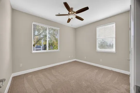 an empty room with fan and windows