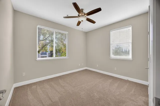an empty room with fan and windows
