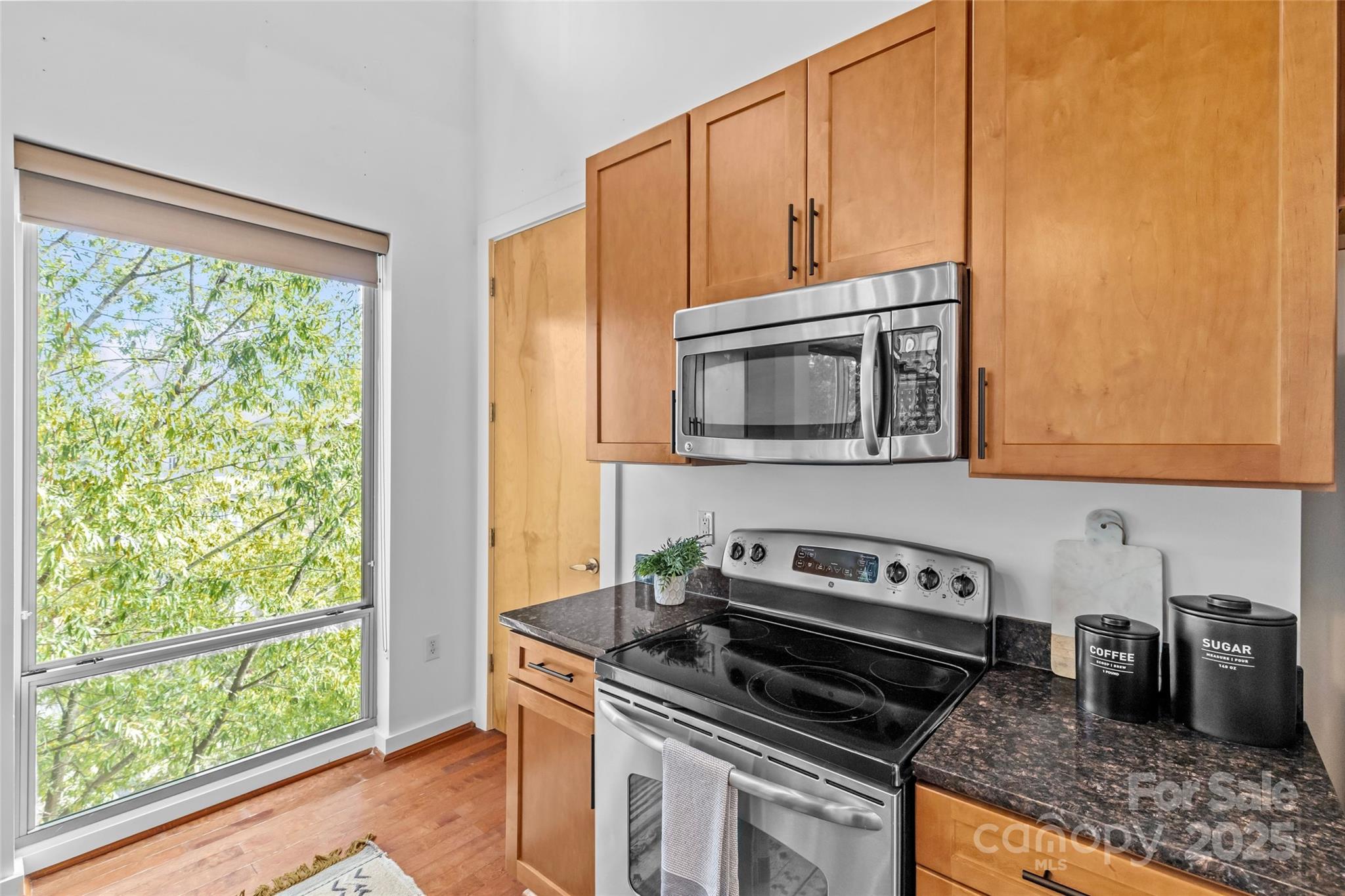 2116 McClintock Road, Unit 232 Charlotte, NC 28205 - Photo 26 of 48 a kitchen with a stove a microwave and cabinets