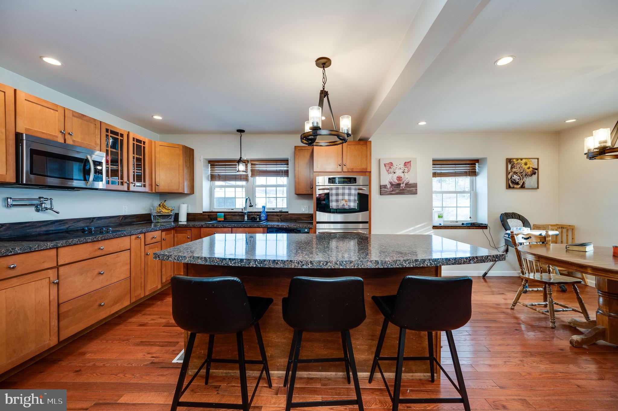 1109 Upper Van Reed Road Leesport, PA 19533 - Photo 35 of 72 a kitchen with stainless steel appliances granite countertop a sink a stove a microwave a dining table and chairs