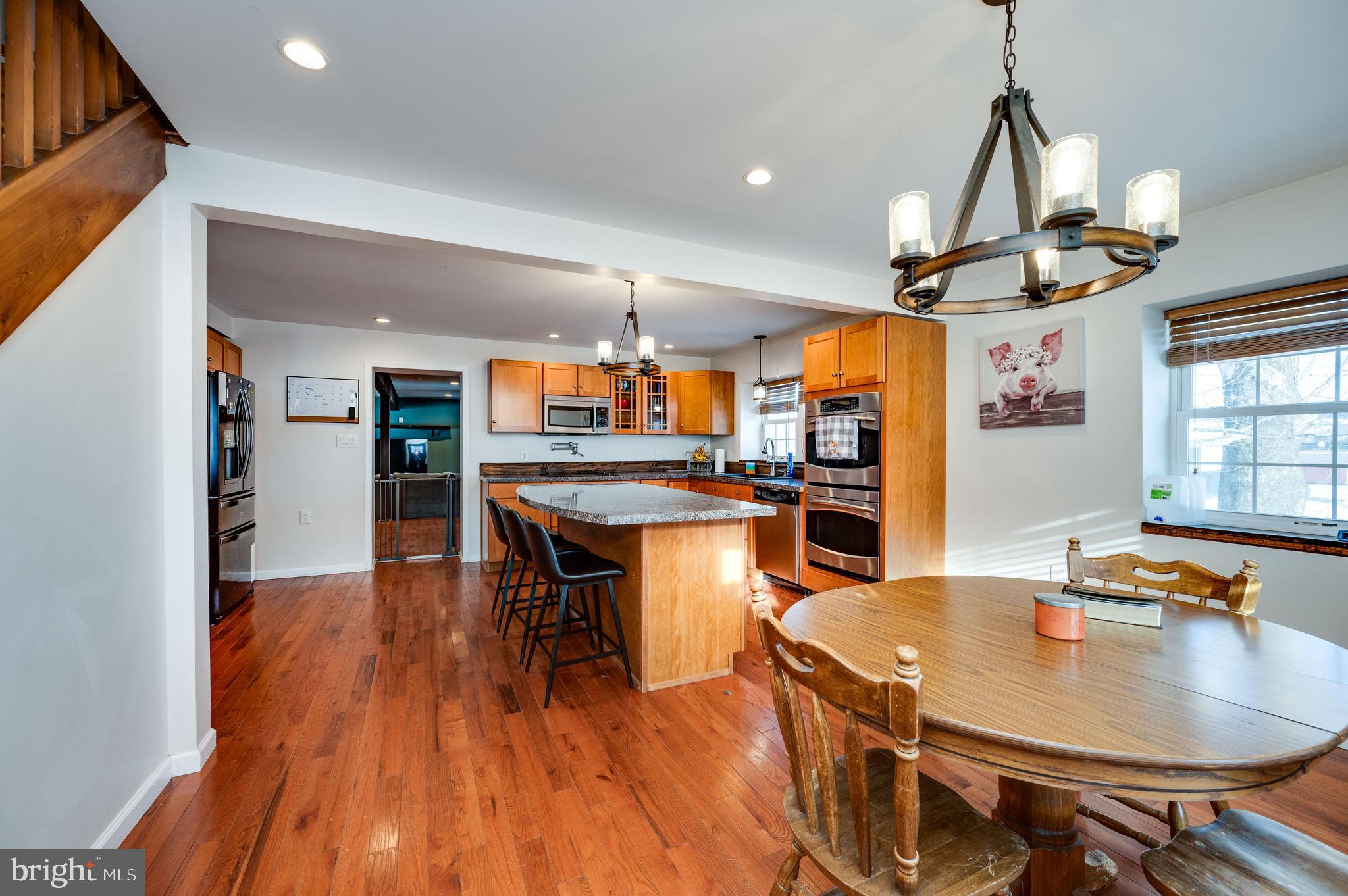 1109 Upper Van Reed Road Leesport, PA 19533 - Photo 39 of 72 a kitchen with stainless steel appliances granite countertop a sink dishwasher and a dining table with wooden floor