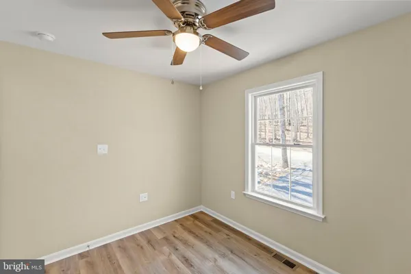 an empty room with a window and wooden floor