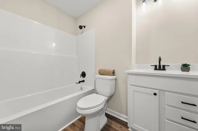 an empty room with wooden floor closet and fan