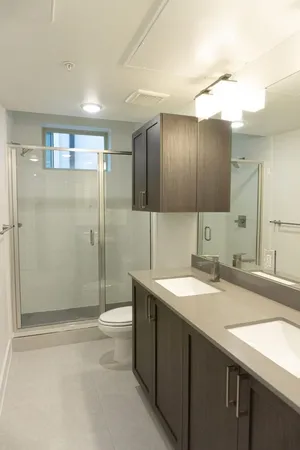 a bathroom with a sink a toilet and shower