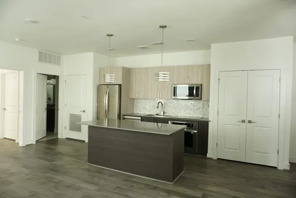 a large kitchen with stainless steel appliances granite countertop a stove and a refrigerator
