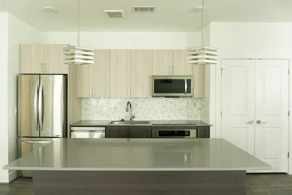 a kitchen with stainless steel appliances granite countertop a sink and a refrigerator