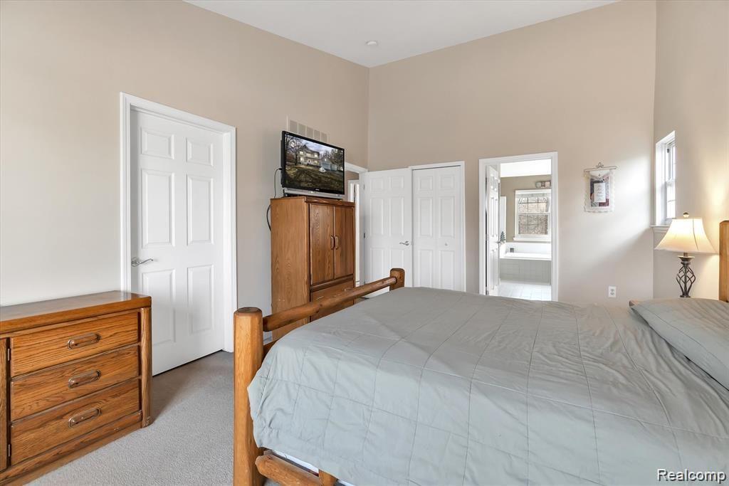 201 Timber Ridge Drive Highland, MI 48357 - Photo 20 of 39 Second floor primary bedroom with vaulted ceiling, walk-in closet and en-suite bath