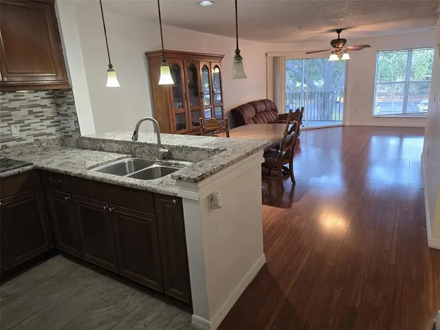 a kitchen with sink and view of living room