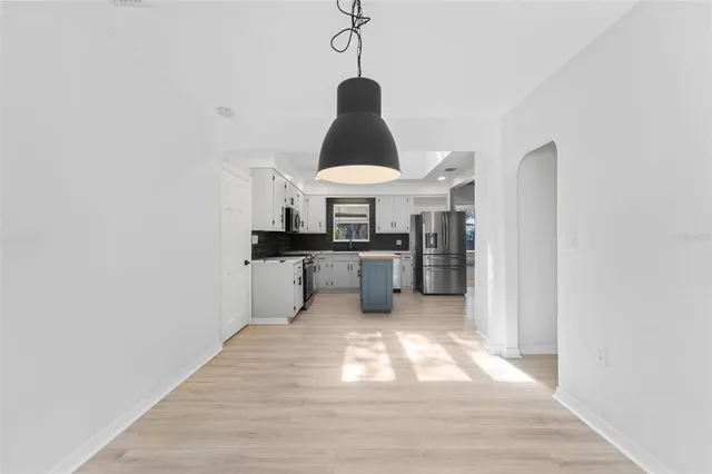 a kitchen with stainless steel appliances granite countertop a sink a stove and a wooden floors