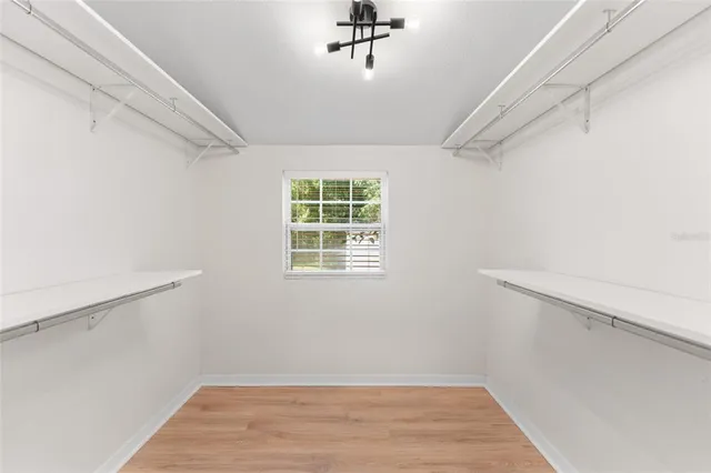 a view of a hallway with wooden floor and a window