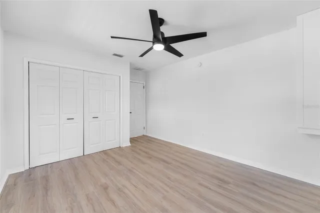 a view of empty room with wooden floor