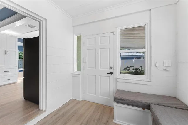 a view of a hallway with wooden floor and cabinet