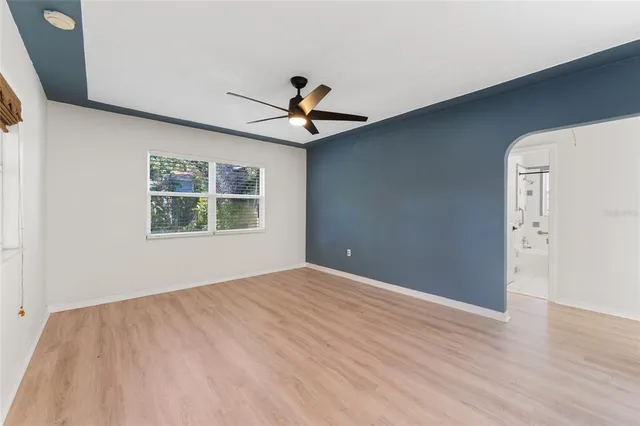 a view of an empty room with window and wooden floor