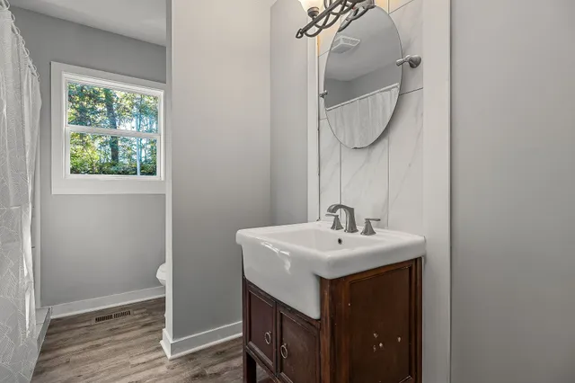 a bathroom with a sink a mirror and a window