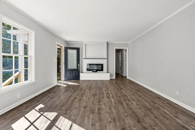 a view of empty room with wooden floor and window