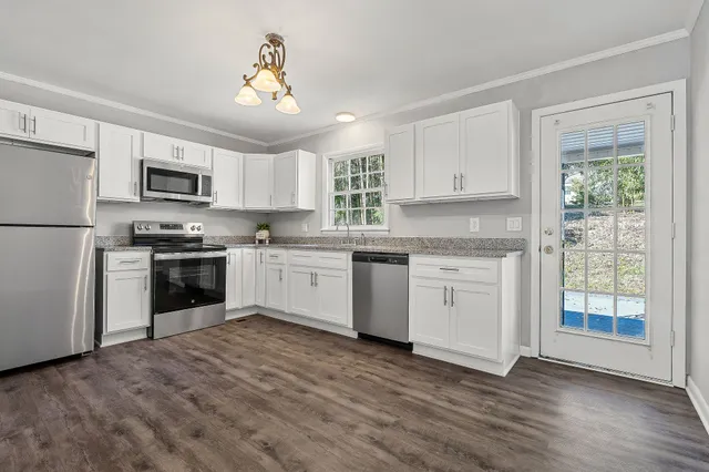 a kitchen with granite countertop white cabinets and white appliances