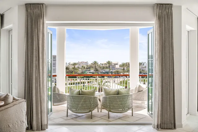 a balcony with furniture and a floor to ceiling window