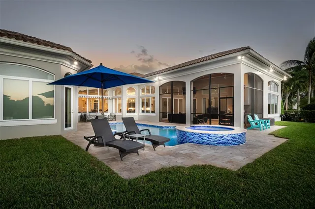 a front view of a house with swimming pool and porch with furniture