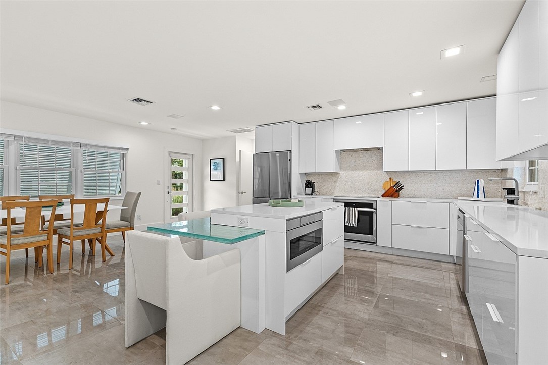 774 Azalea Lane Vero Beach, FL 32963 - Photo 11 of 34 a kitchen that has a lot of cabinets in it and appliances