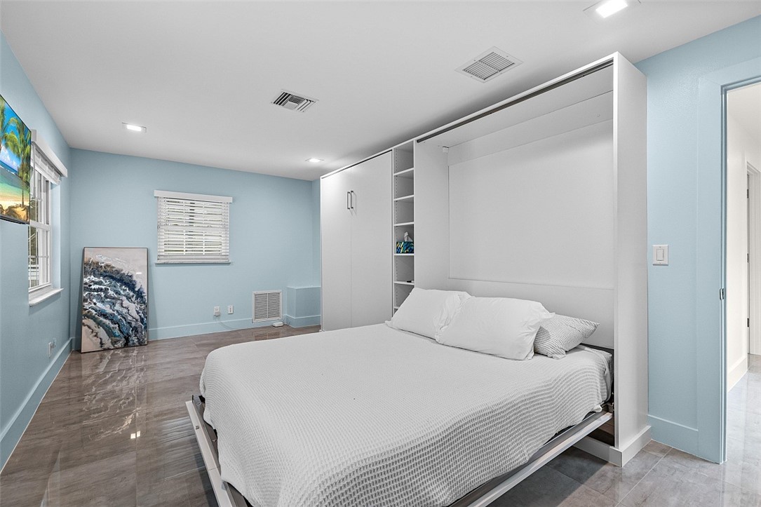 774 Azalea Lane Vero Beach, FL 32963 - Photo 23 of 34 a bedroom with a bed and a chandelier