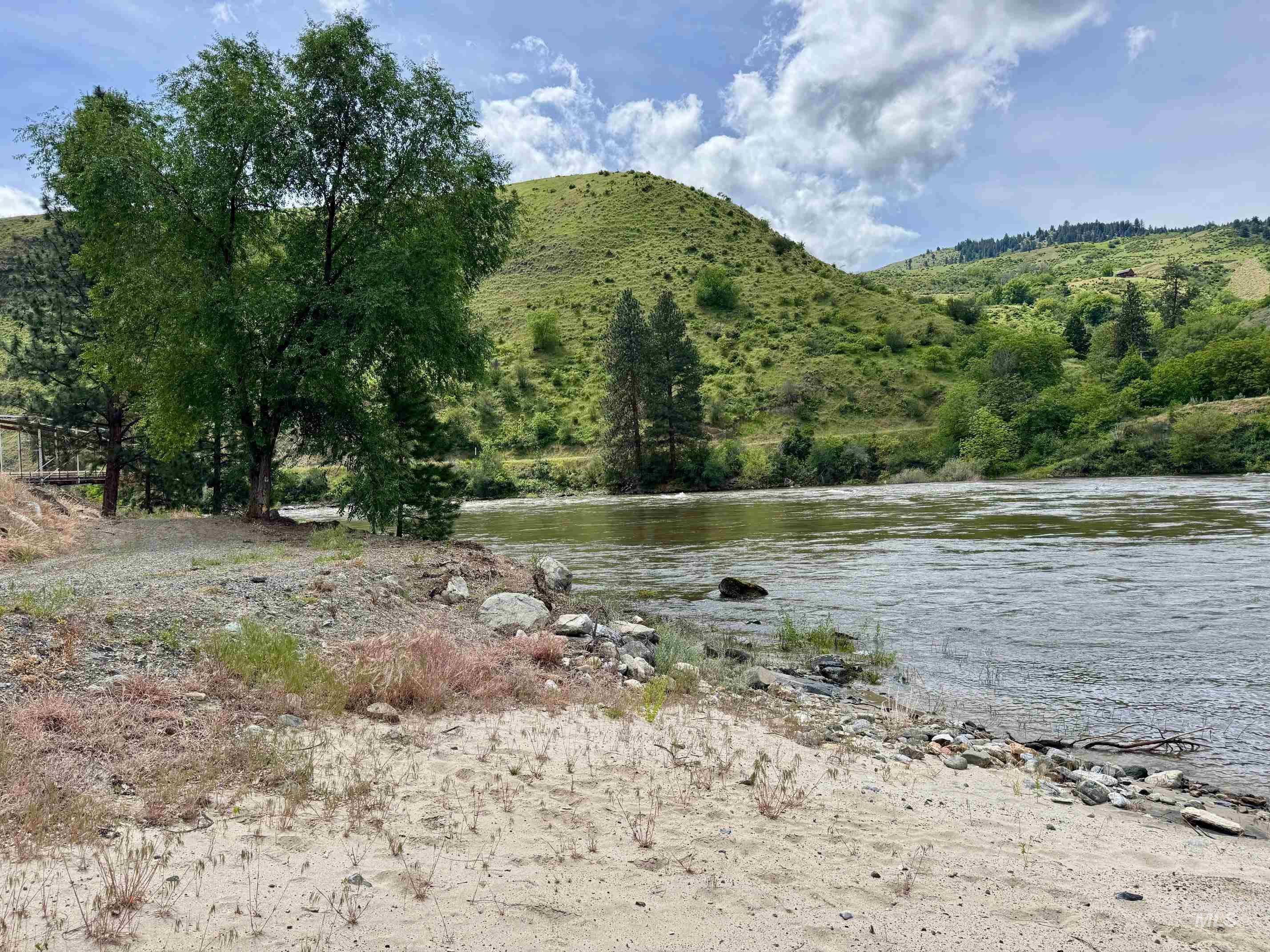 151 Cow Creek Road Lucile, ID 83542 - Photo 48 of 50 Riverfront property featuring a sandy bank, mature trees, and natural hillside landscaping