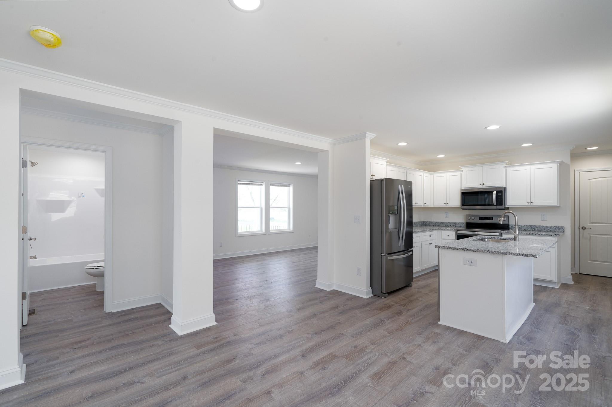 6205 Faith Road Salisbury, NC 28146 - Photo 12 of 33 a view of kitchen with refrigerator stove and wooden floor