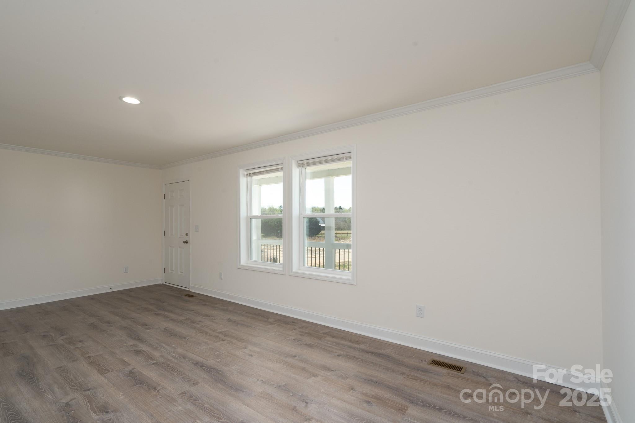 6205 Faith Road Salisbury, NC 28146 - Photo 22 of 33 an empty room with wooden floor and windows