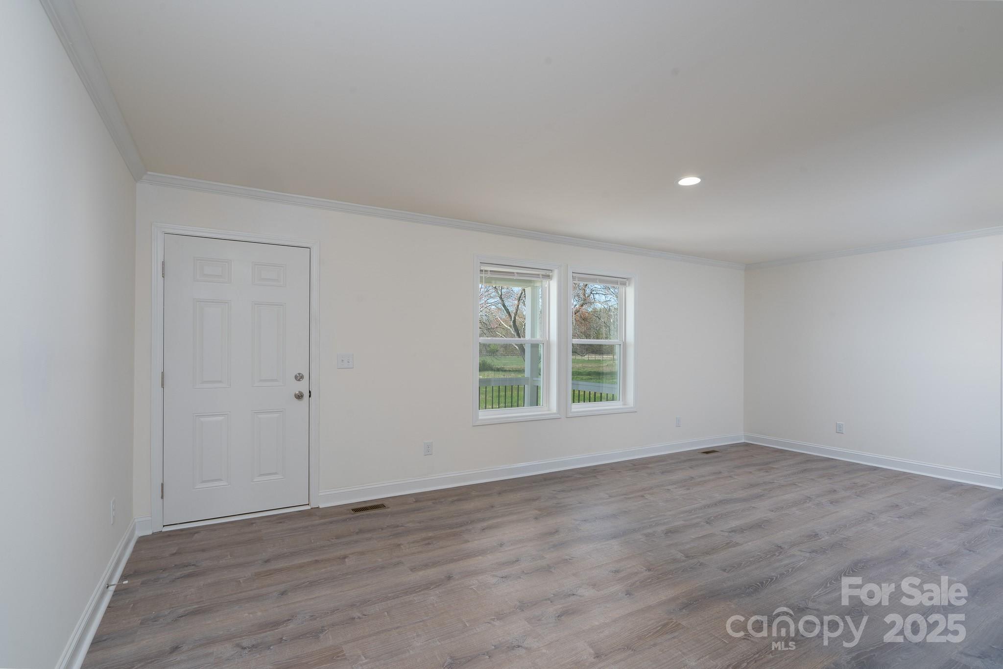 6205 Faith Road Salisbury, NC 28146 - Photo 23 of 33 an empty room with wooden floor and windows