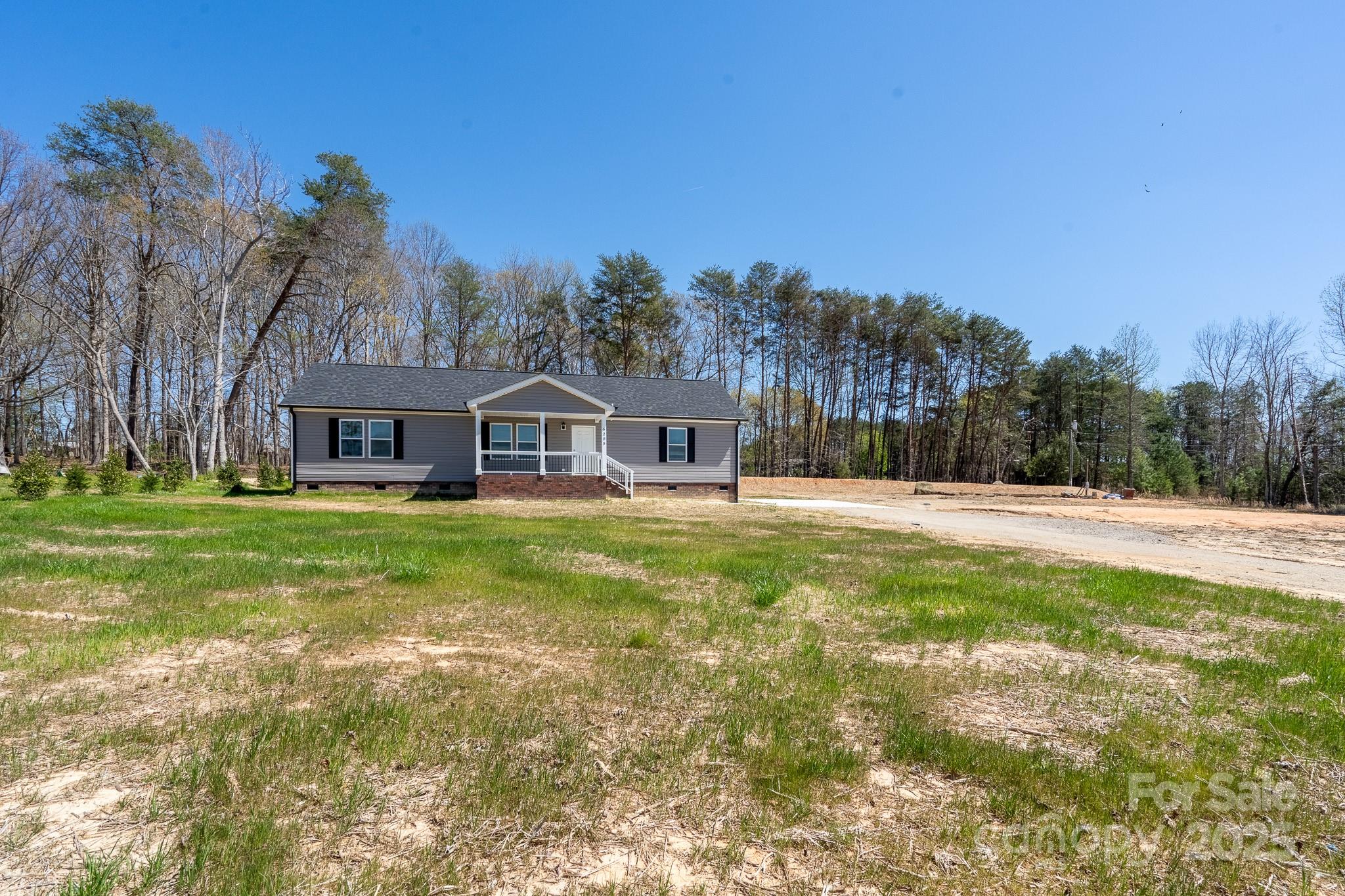 6205 Faith Road Salisbury, NC 28146 - Photo 3 of 33 a front view of house with yard and trees in the background