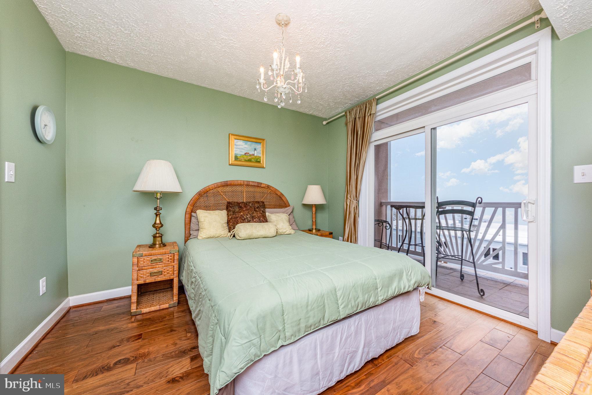 100 Taylor Street, Unit 505 Colonial Beach, VA 22443 - Photo 4 of 22 a bedroom with a bed and a chandelier