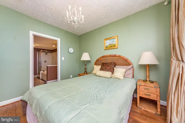 a bedroom with a bed and a chandelier