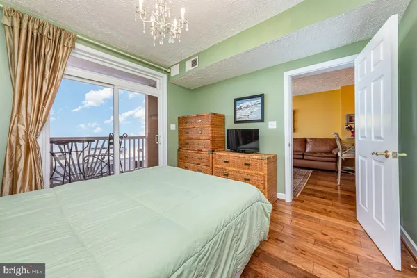 a bedroom with a bed and a large window with wooden floor