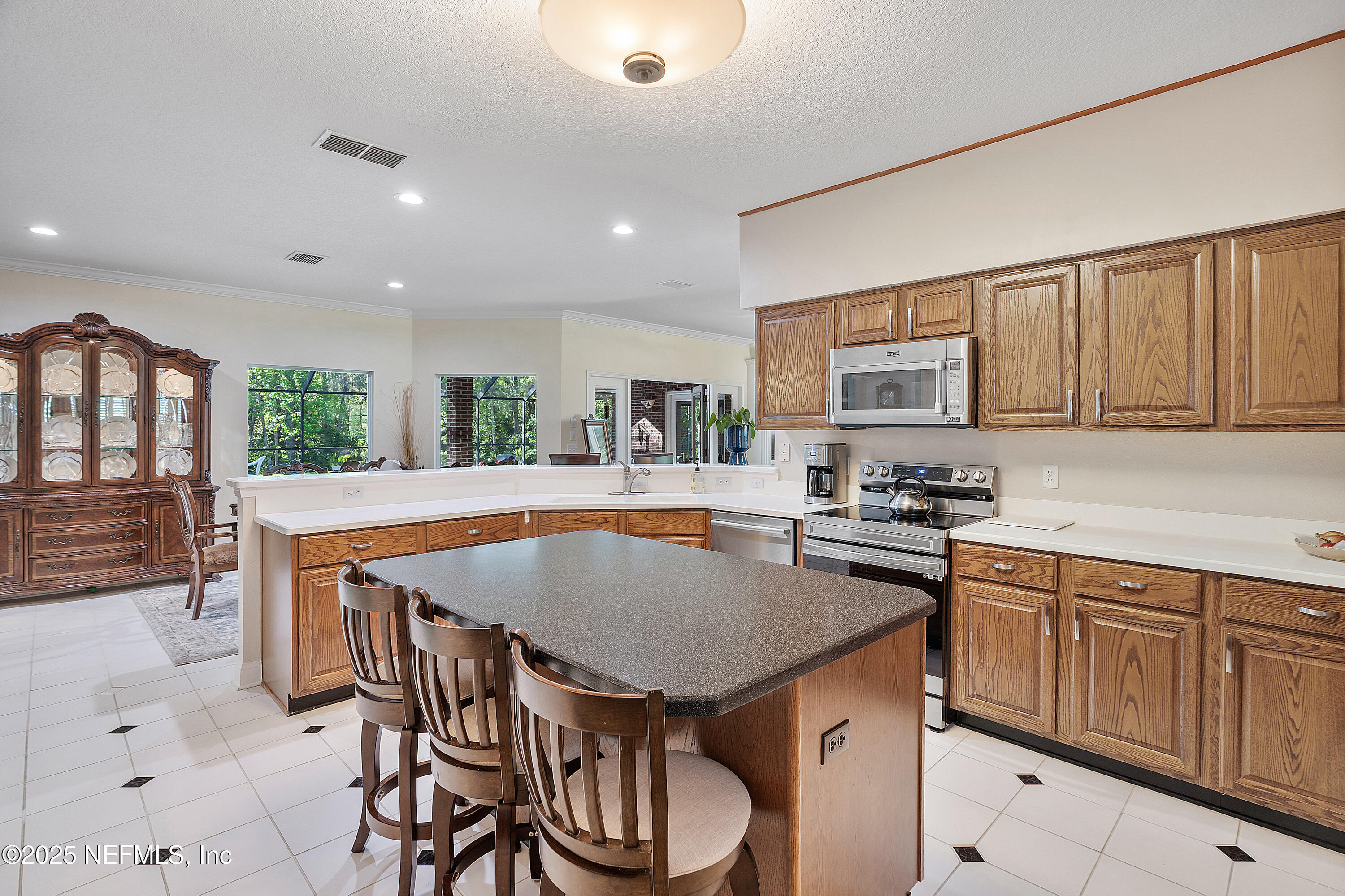2688 Seneca Drive St. Johns, FL 32259 - Photo 16 of 62 a kitchen with a table chairs microwave and cabinets
