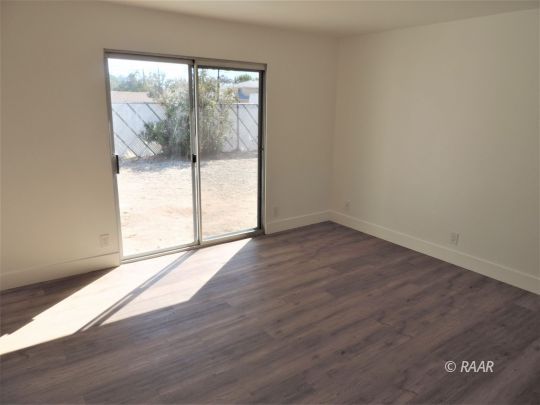 709 West Alene Avenue Ridgecrest, CA 93555 - Photo 9 of 20 an empty room with wooden floor and windows