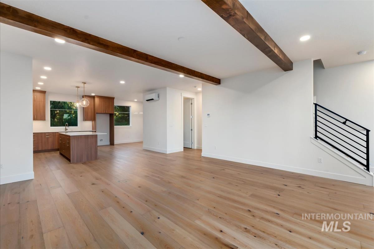 3213 West Moore Street Boise, ID 83702 - Photo 15 of 32 Spacious open-concept interior featuring light wood-finish flooring, exposed ceiling beams, and recessed lighting