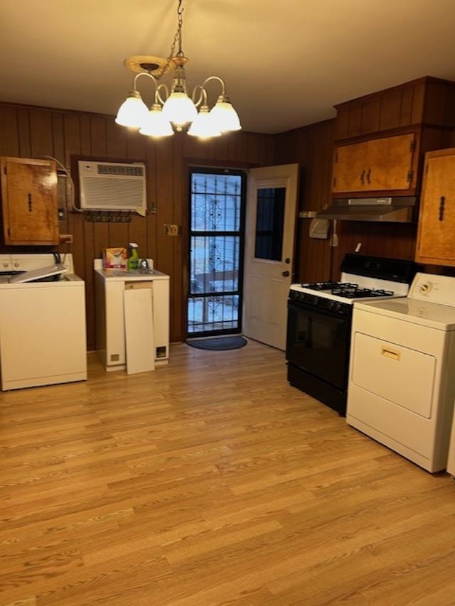 7030 Asbury Glimp Road Ripley, TN 38063 - Photo 13 of 22 Kitchen featuring gas stove, a chandelier, pendant lighting, wooden walls, and light wood finished floors