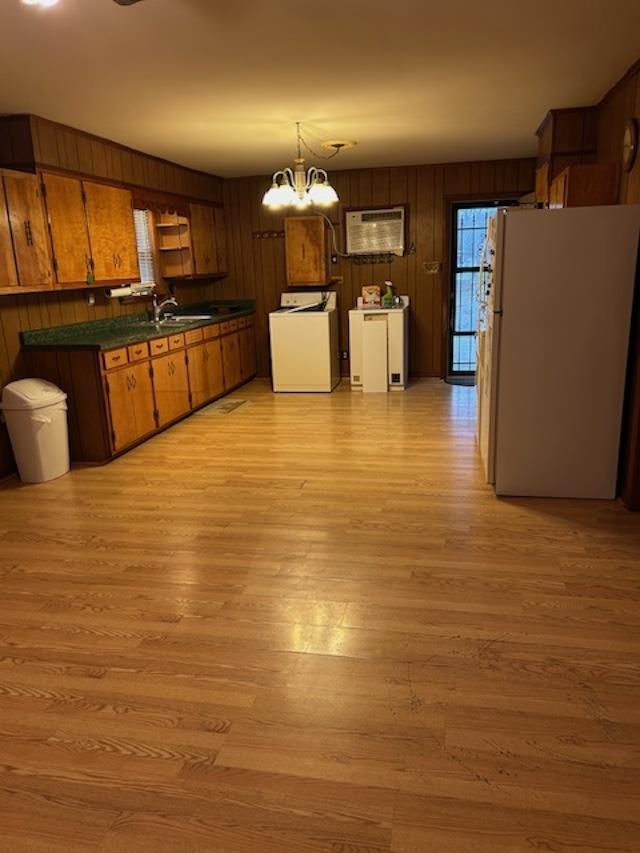 7030 Asbury Glimp Road Ripley, TN 38063 - Photo 14 of 22 Kitchen featuring dark countertops, freestanding refrigerator, brown cabinetry, wood walls, and washer / clothes dryer