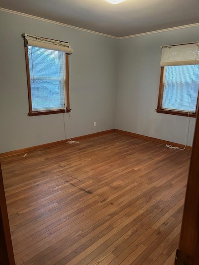 7030 Asbury Glimp Road Ripley, TN 38063 - Photo 18 of 22 Empty room with crown molding, healthy amount of natural light, and hardwood / wood-style floors